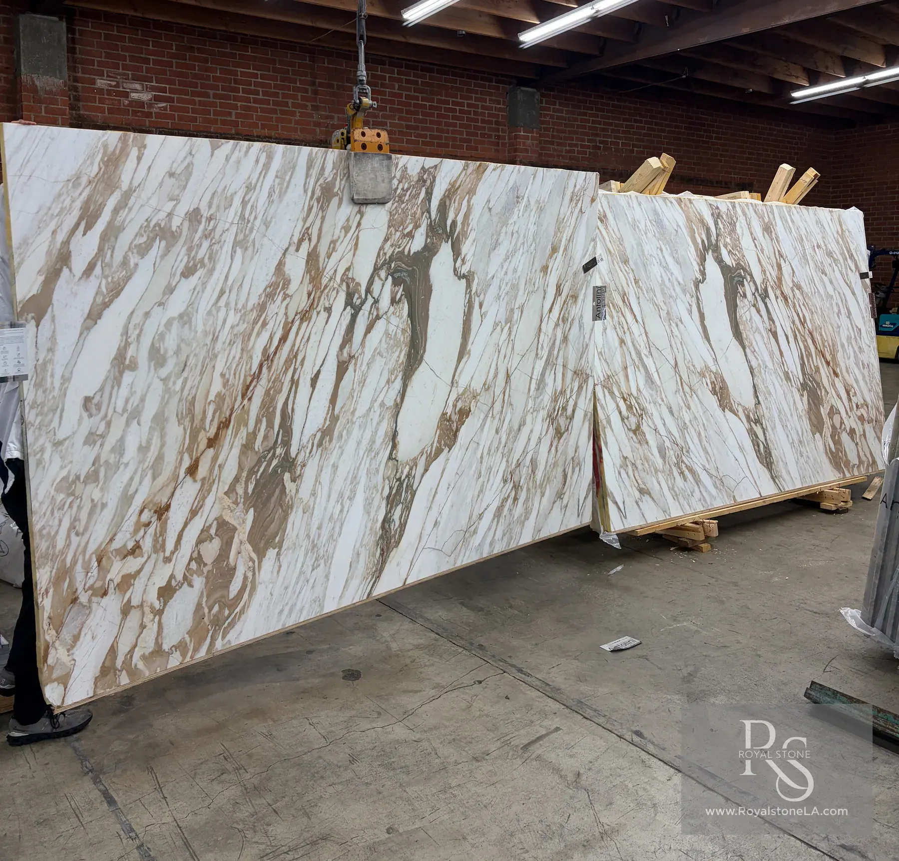 Antolini Calacatta Monet Oro Classic EE505 honed marble slabs staged together in the Royal Stone yard, showing matching warm gold and taupe movement across the white fields